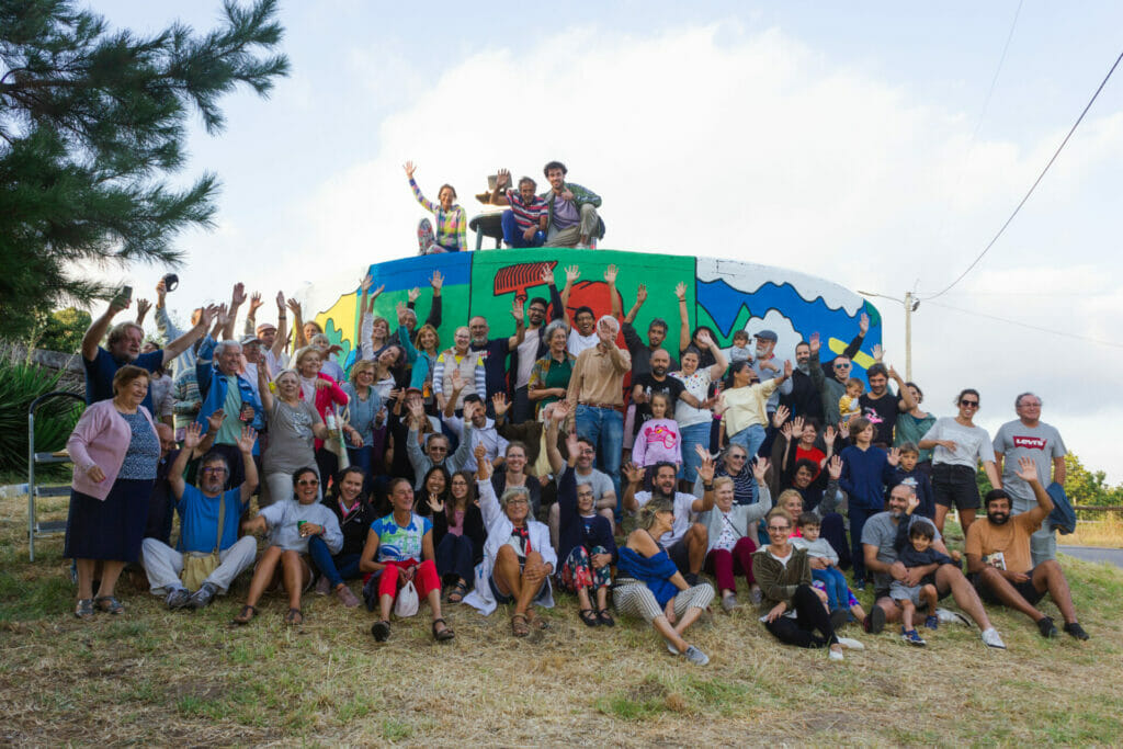 Members of Anceu Coliving pictured with locals in front of the old water depository in the area that was revamped as a collective effort. 